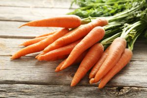 Whole carrots on a wood surface