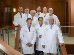Professional group shot of 9 pulmonary physicians in white lab coats