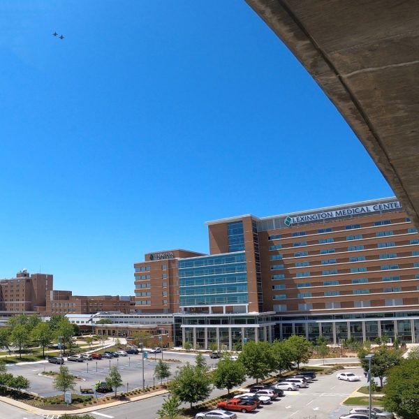 Two planes from the 157th Fighter Wing of the McEntire Air National Guard flying over the Lexington Medical Center parking lot and main building.