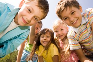 The view of a group of children circling the camera from the ground.