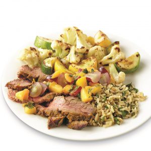 Indian-spiced beef with peach-grape salsa on a white plate
