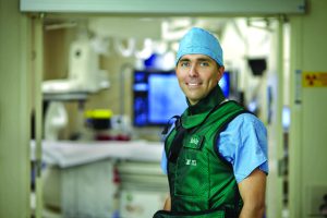 Head shot of a doctor in scrubs in a hospital hallway