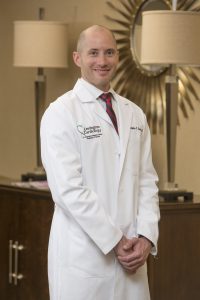Professional lab coat shot of Dr. Christopher Rowley