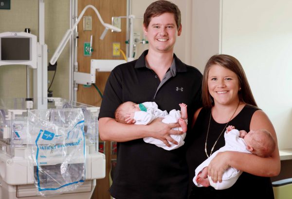 Katie and Jordan hold their newborn babies.