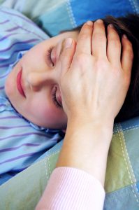 A child laying down while being examined for a temperature