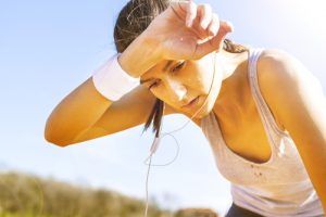 A woman experiencing heat exhaustion while running.