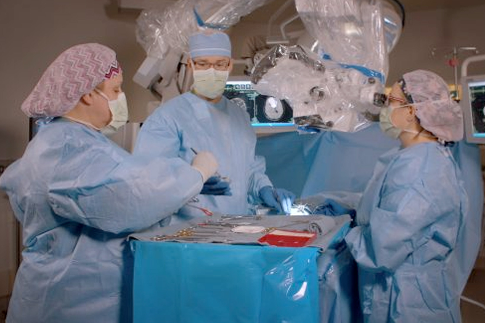 Dr. Johnathan Engh and two assistants in full scrubs prepping for surgery.