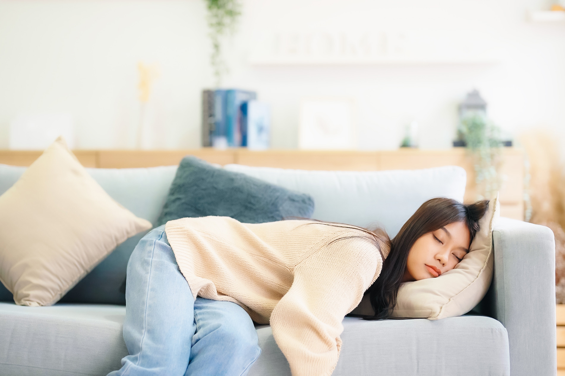 Exhausted young Asian women asleep on couch