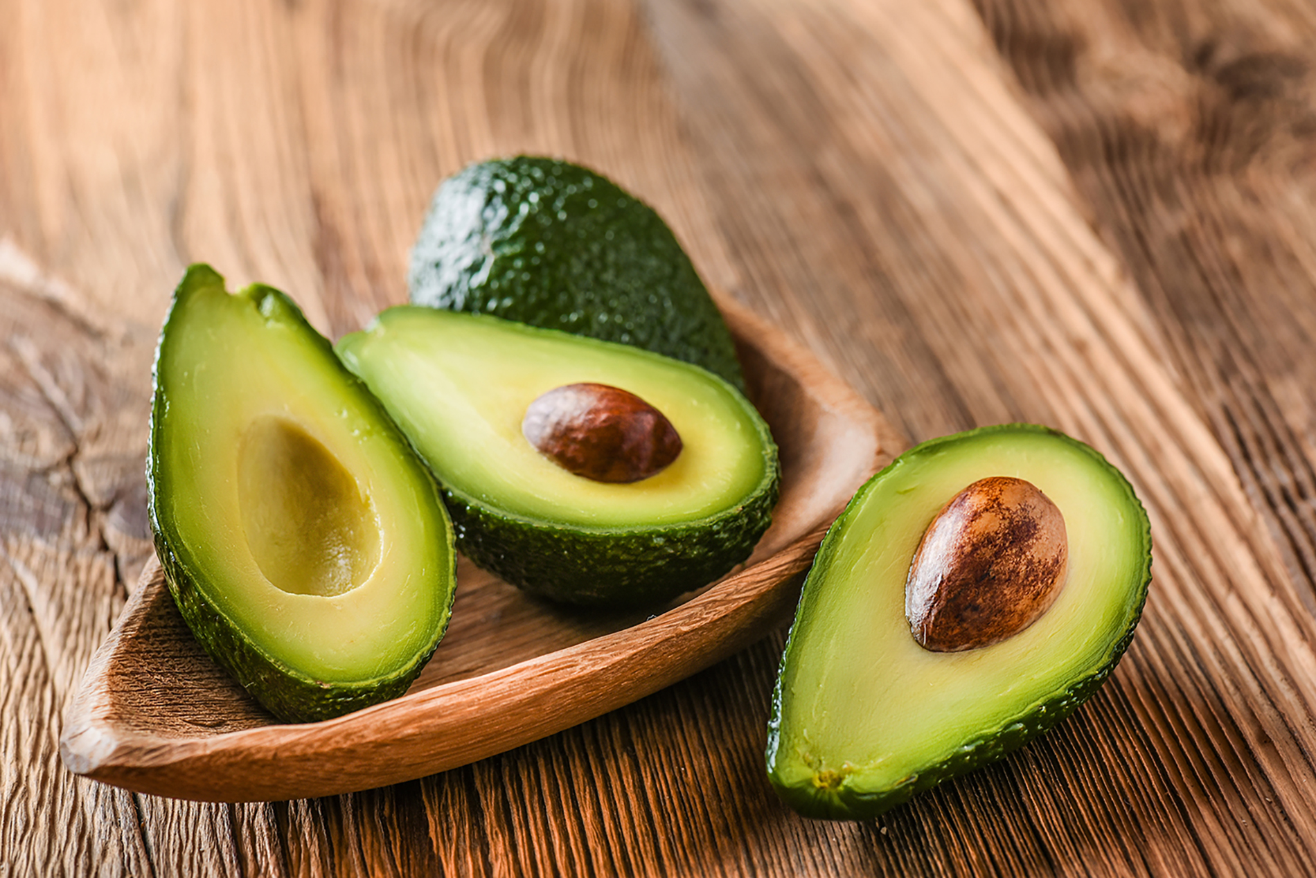 Avocado halves on wooden table