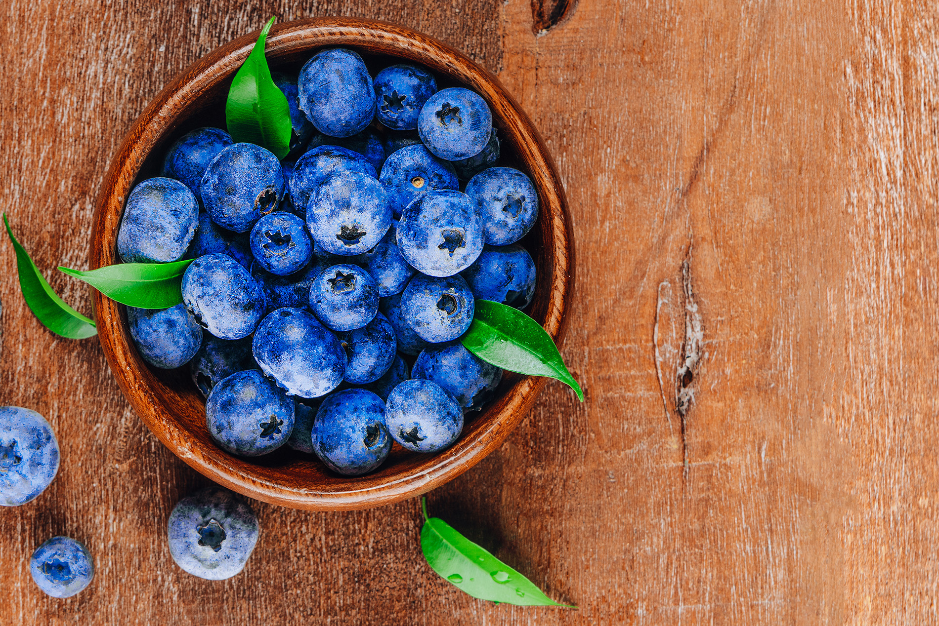 Bowl of blueberries on a wooden board