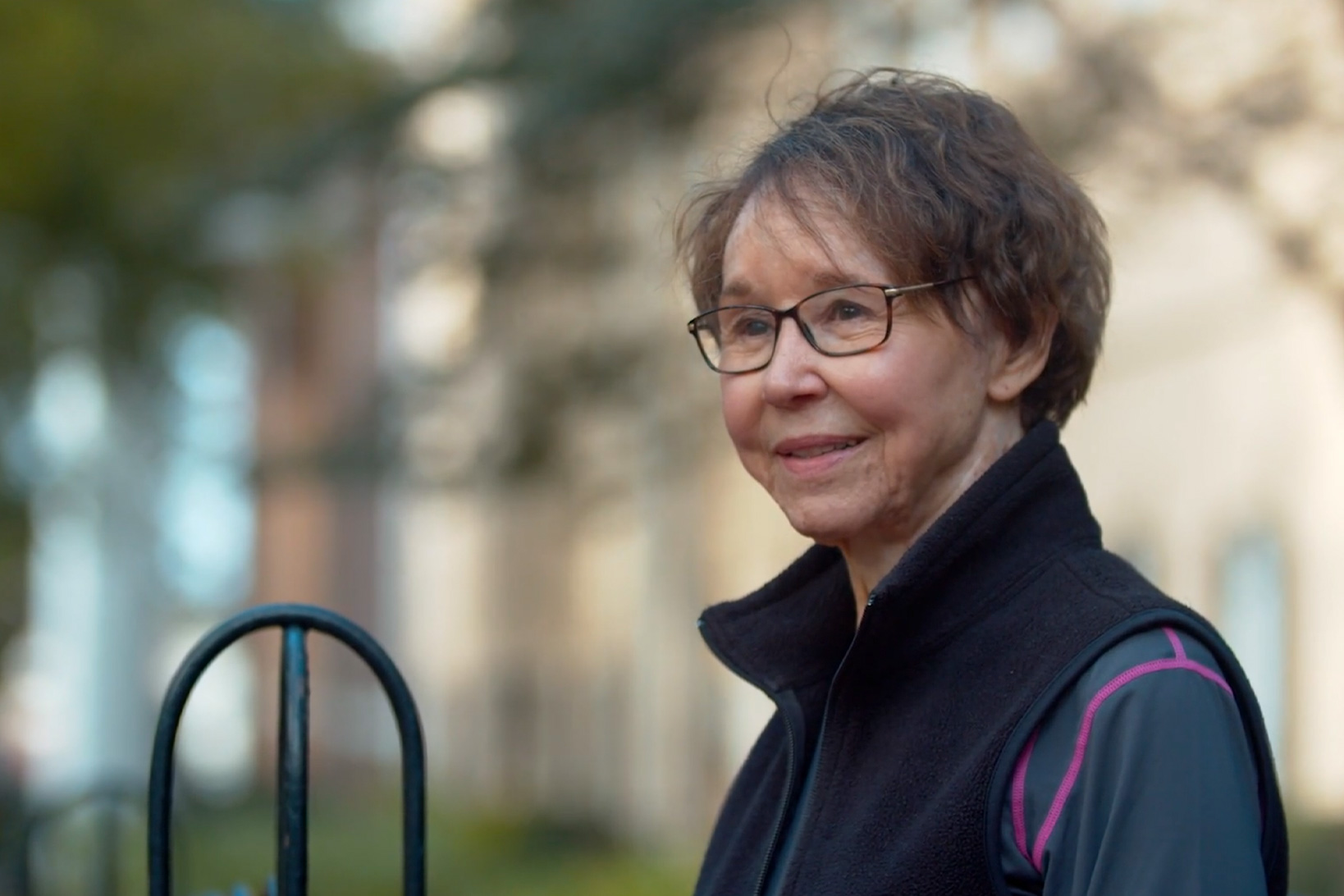 Patient Mary Ann Parsons, smiling slightly, as she sits on a bench in the University of South Carolina Horseshoe park.