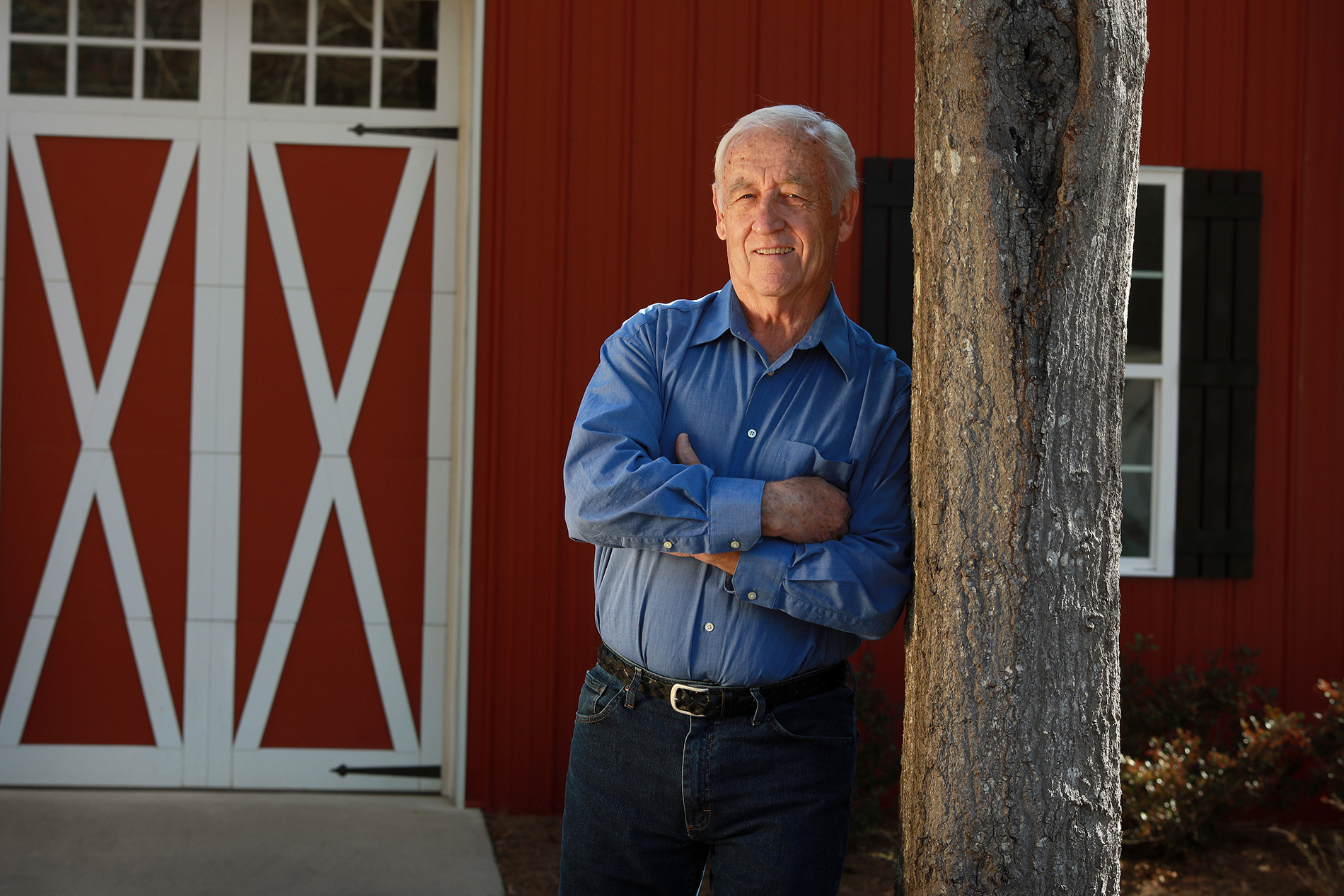 Frank Hallman standing in front of barn