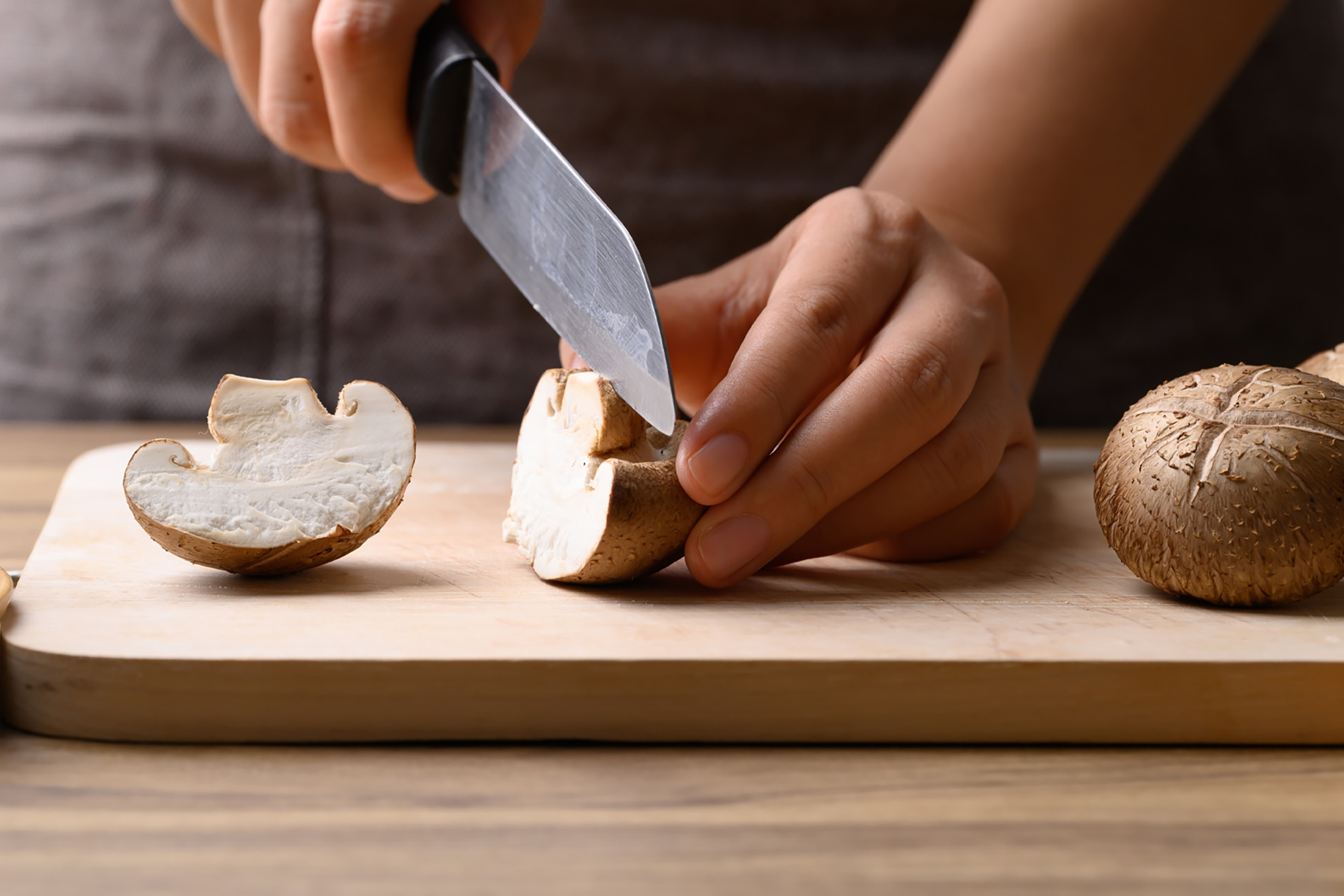 Woman slicing mushrooms on cutting board