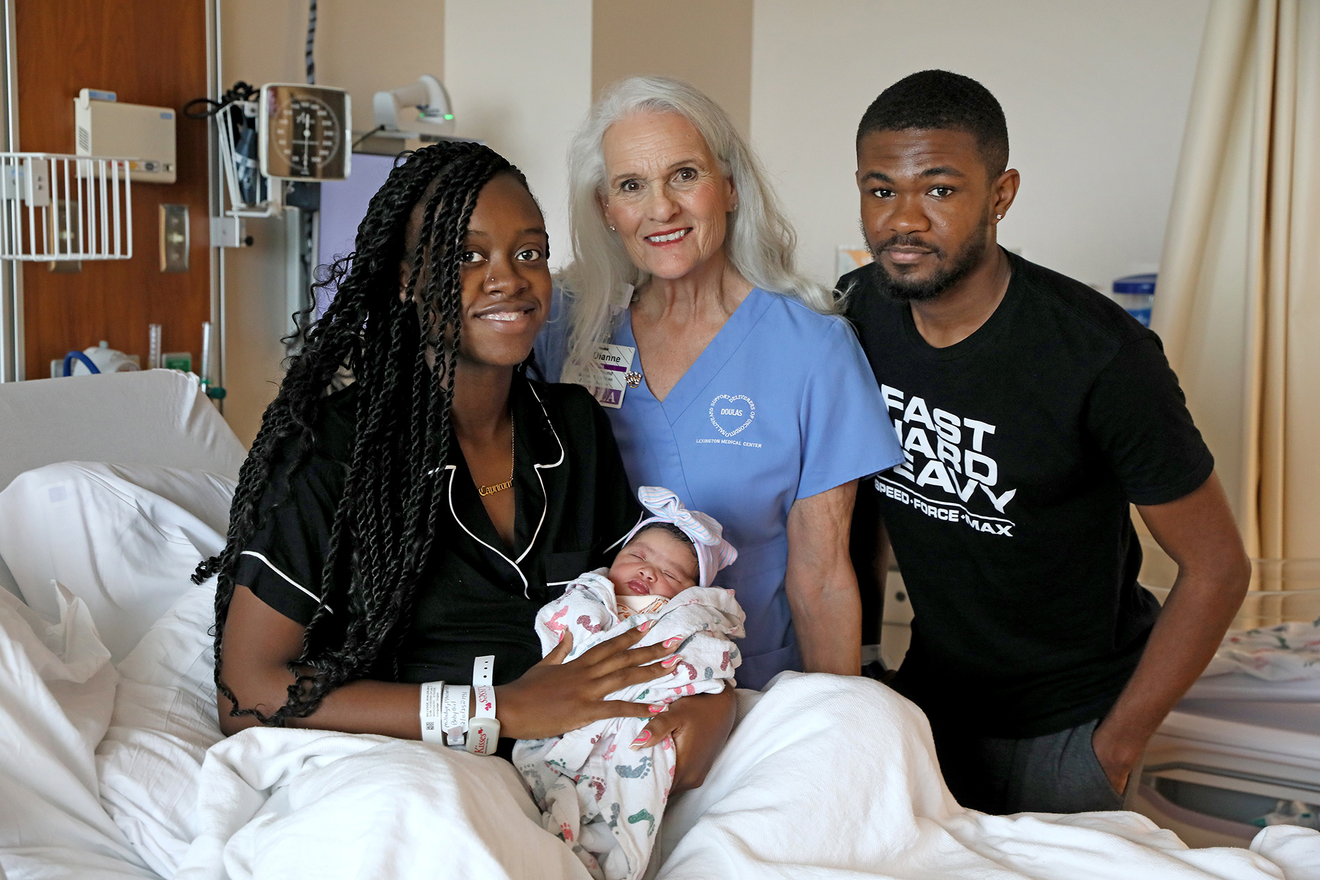 Photo of doula Dianne Pound with new parents and baby