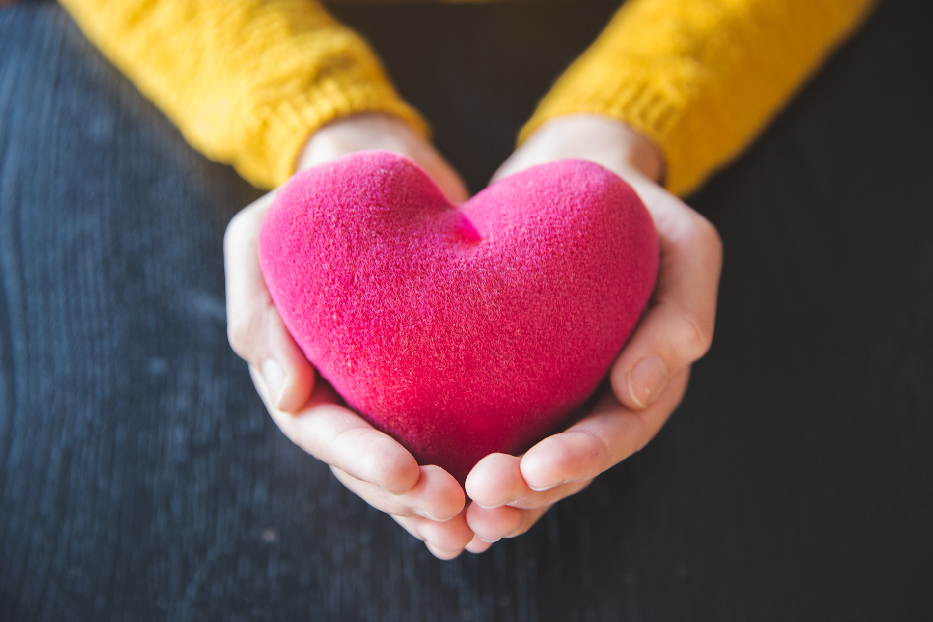 Woman holding pink fabric heart in her hands