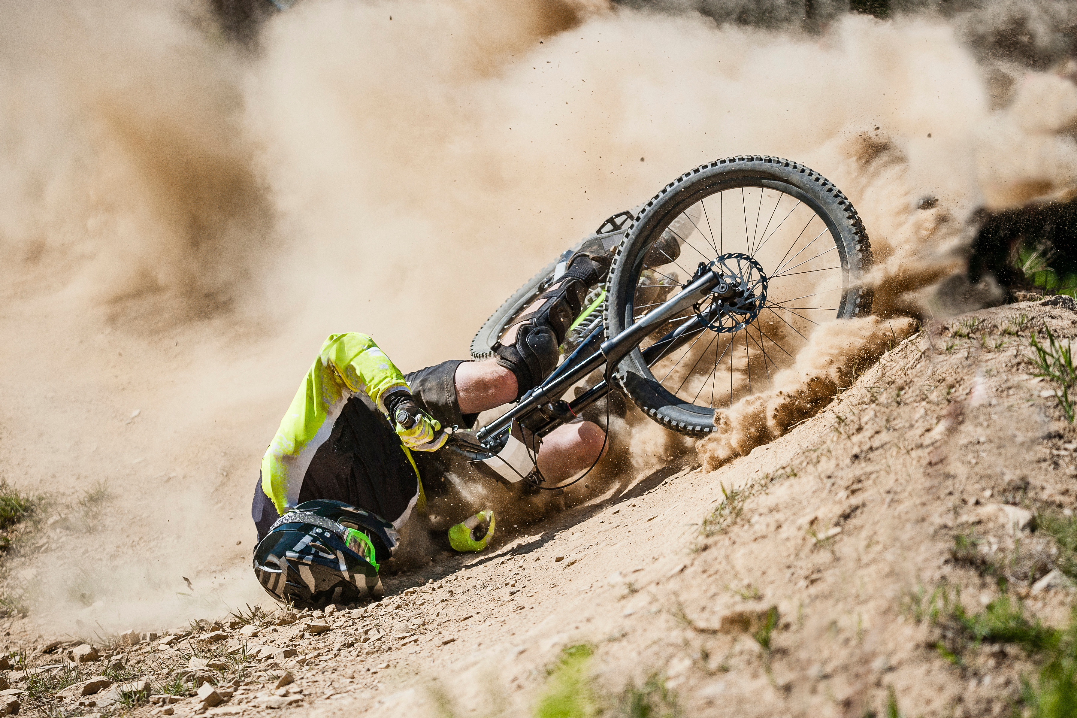 Person crashed mountain bike on dirt hillside