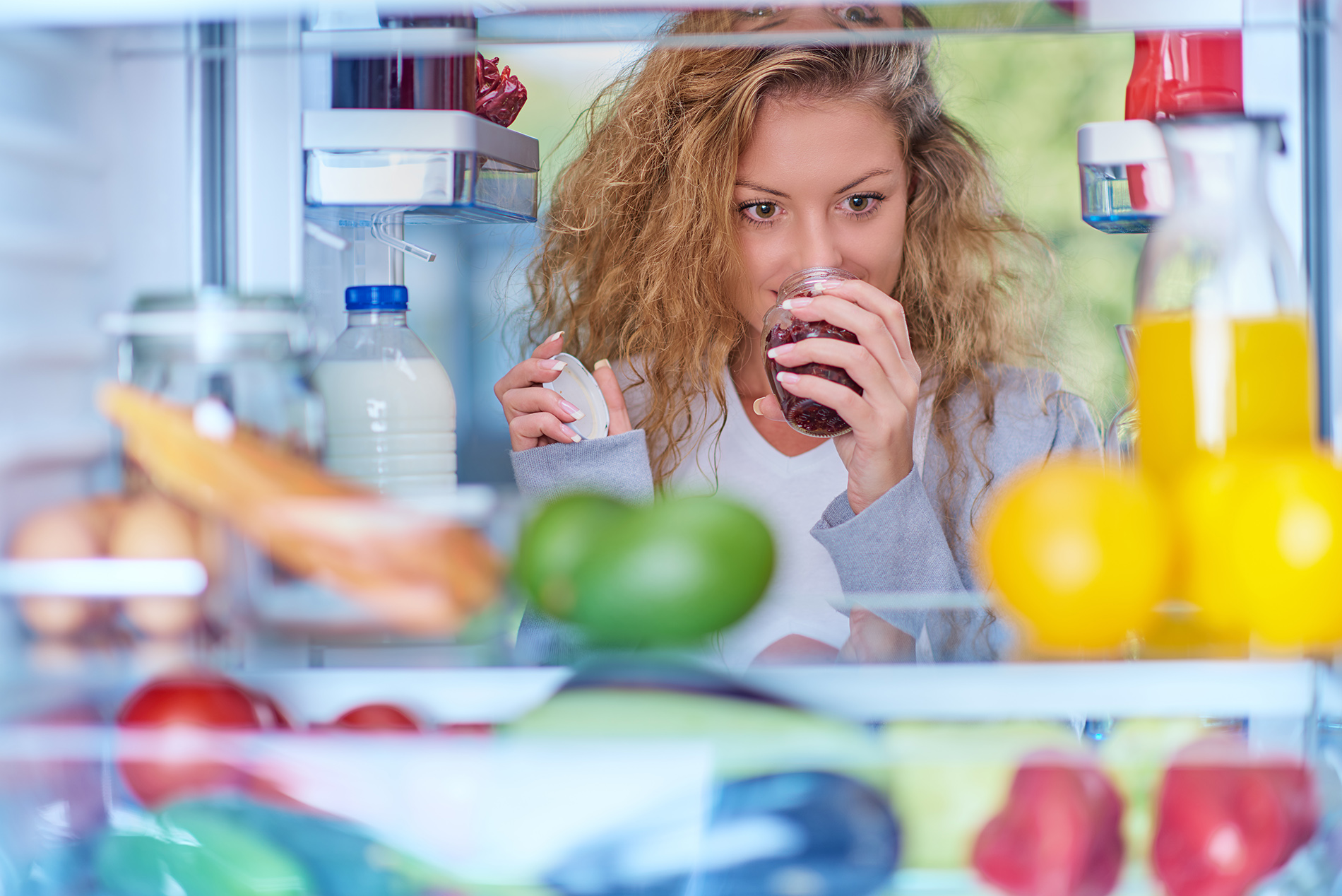 Woman smelling food in refrigerator