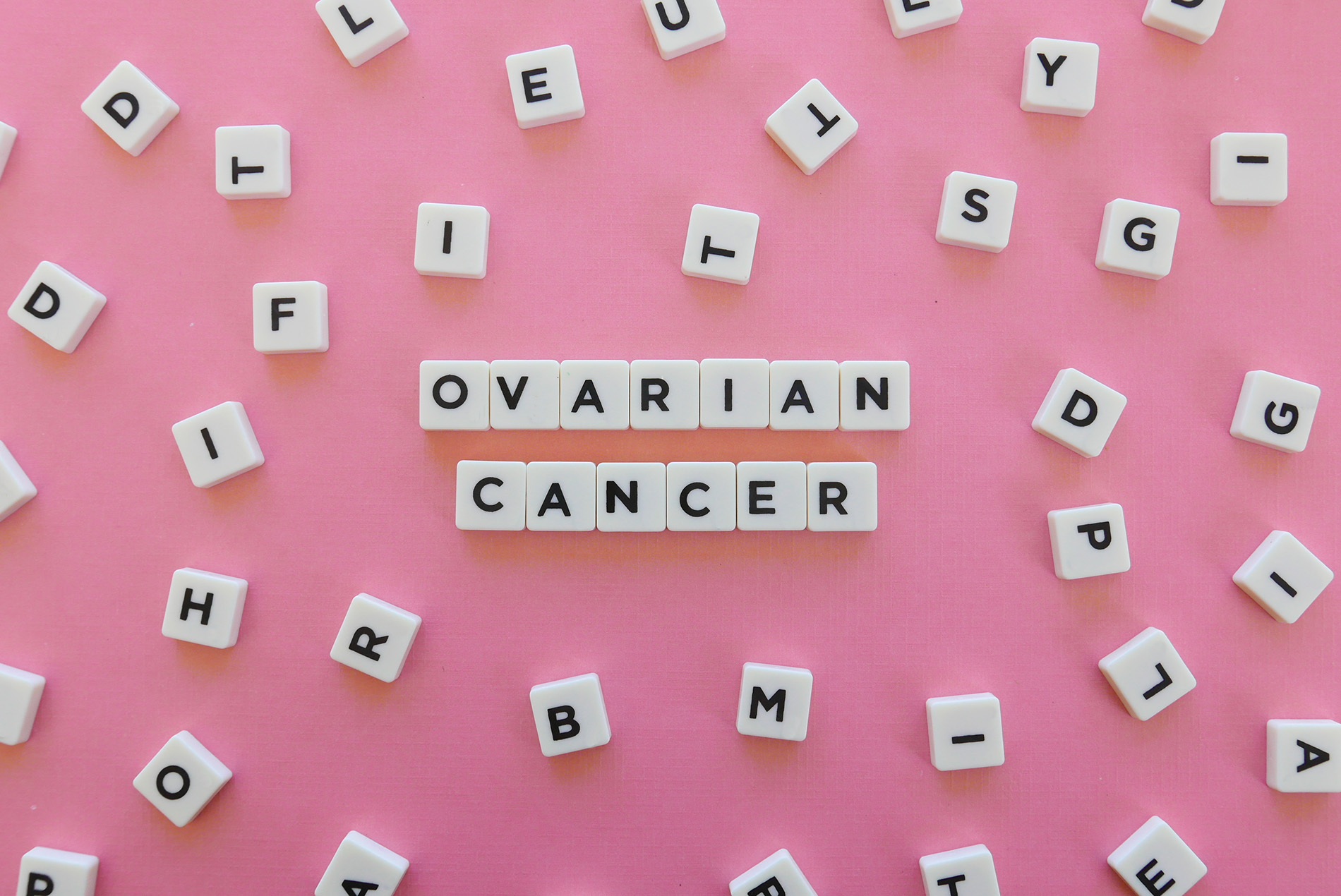 Ovarian cancer spelled out on pink background