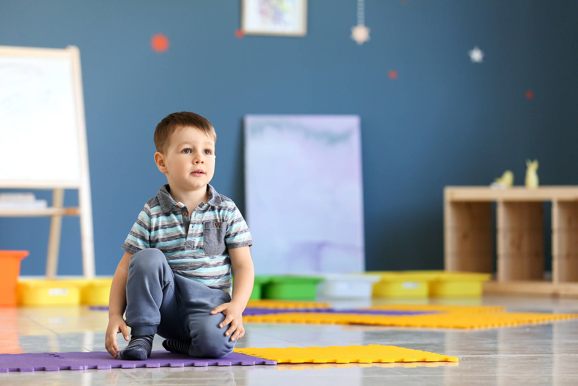 Young boy with autism alone on play mat