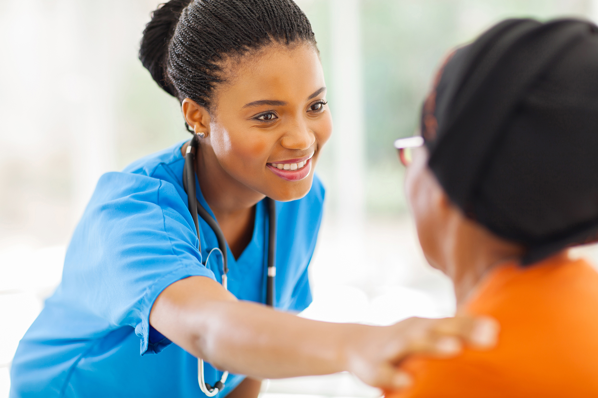 Young African American nurse comforting patient