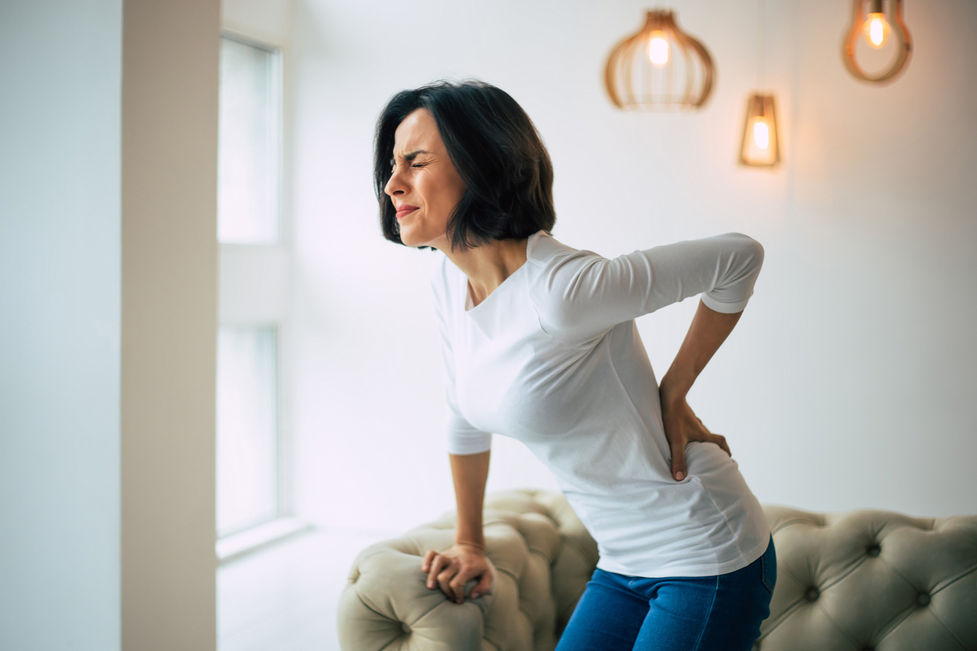 Middle aged woman holding her back in pain