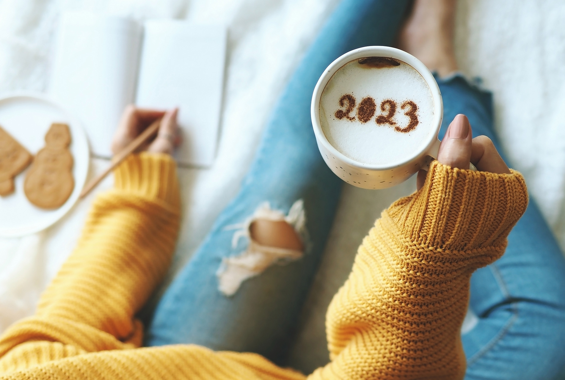 Woman holding mug of coffee that says 2023