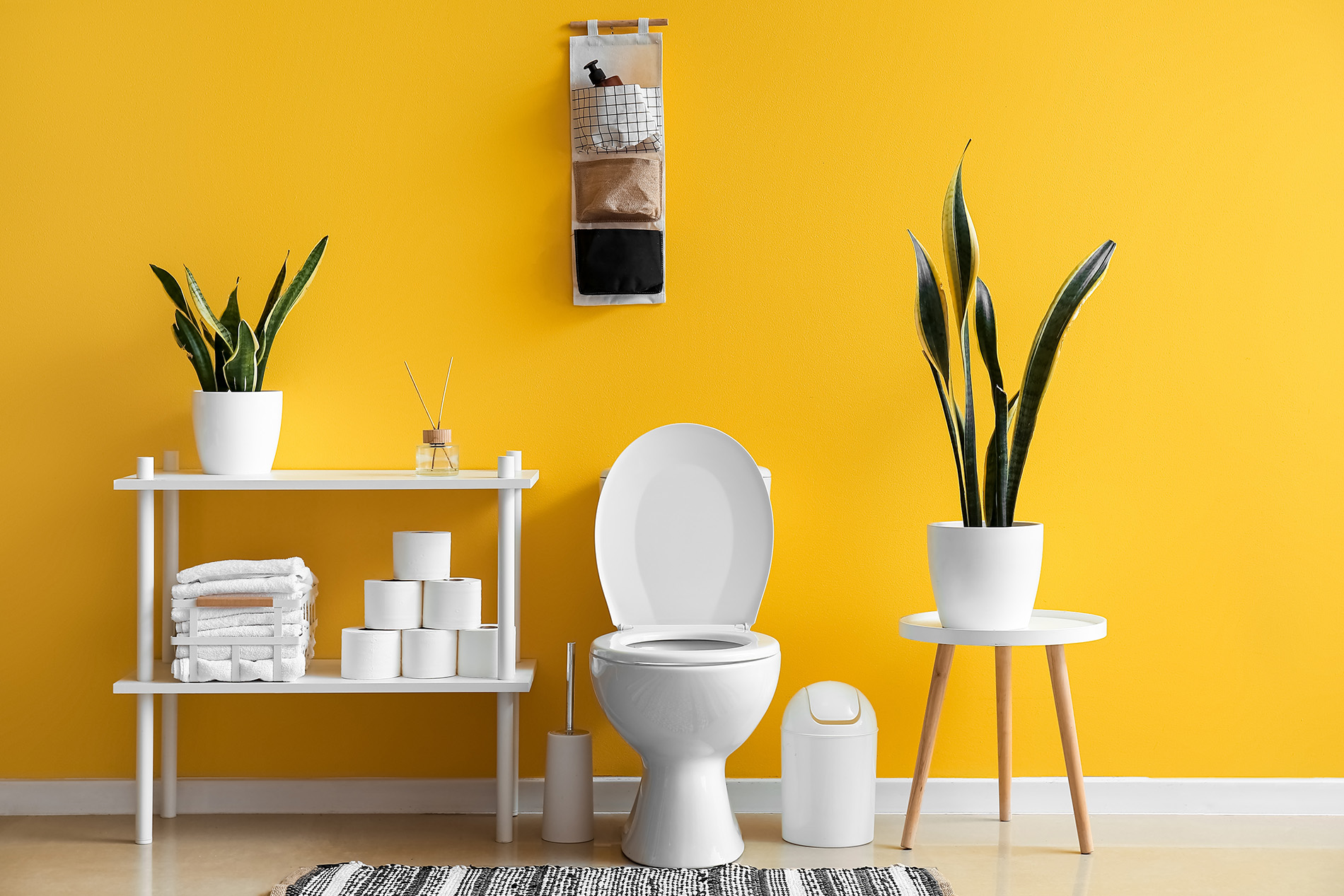 Home bathroom with toilet, shelves, towels and orange walls