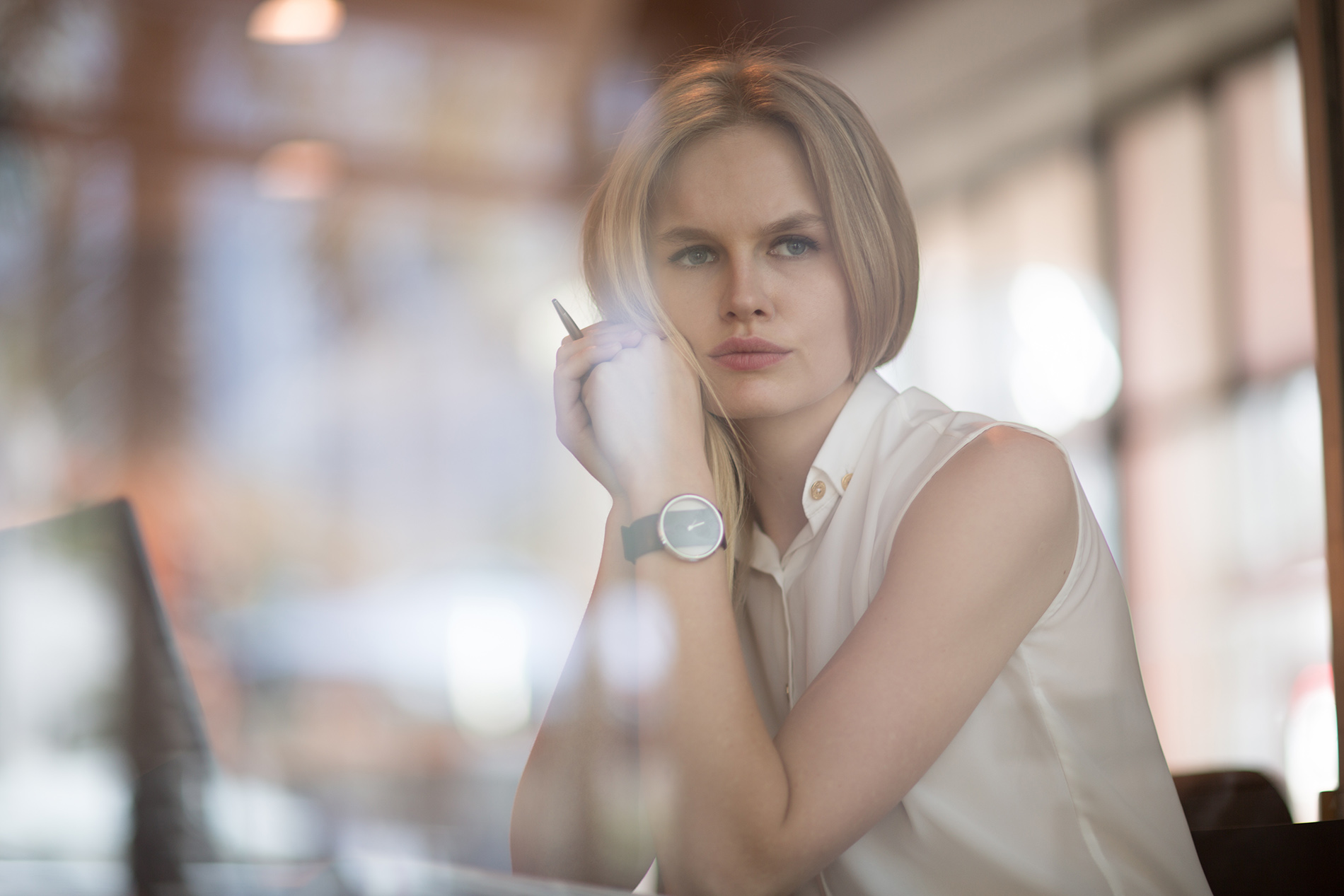 Woman sitting in her office looking out the window with a worried expression