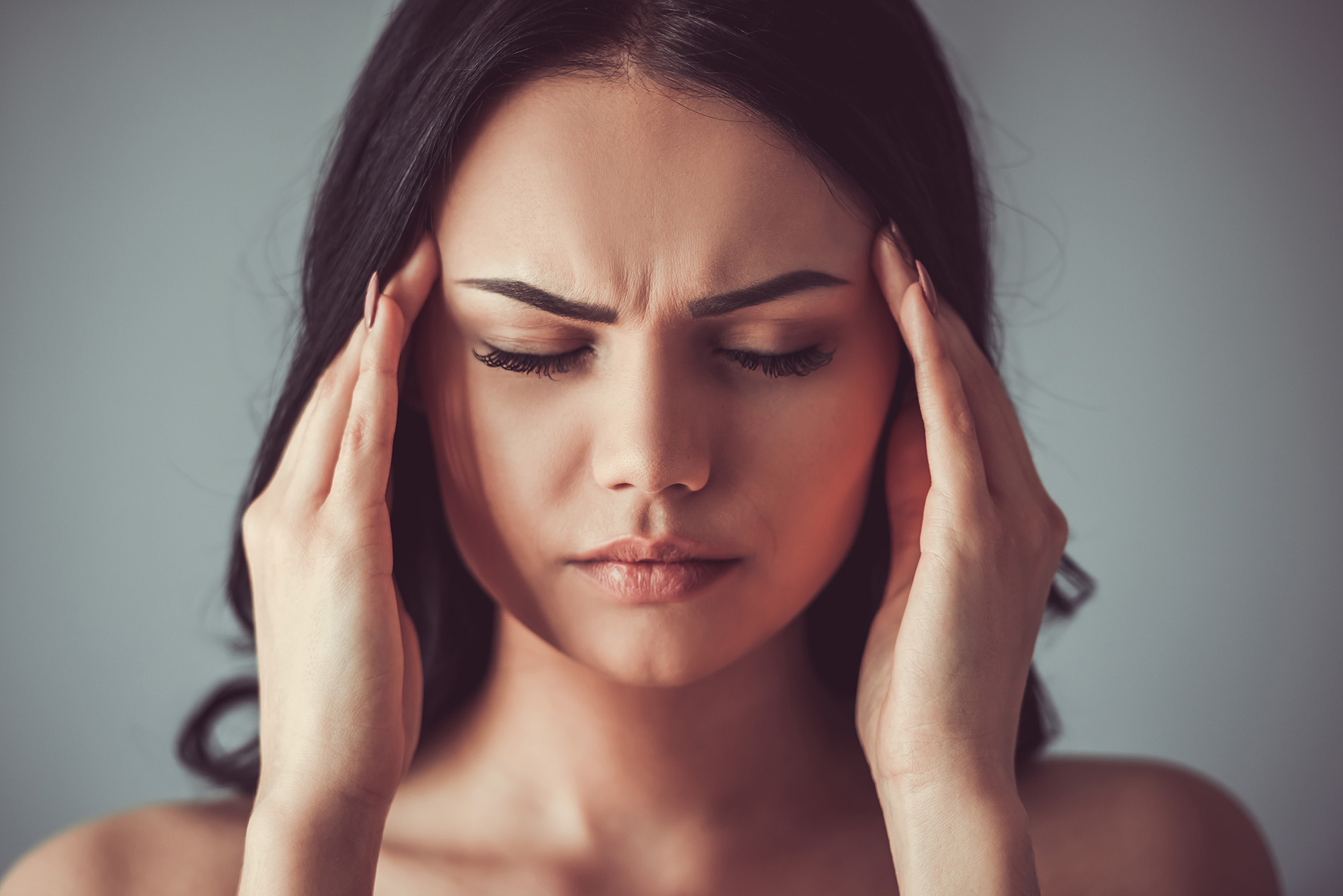 Woman with headache touching her temples