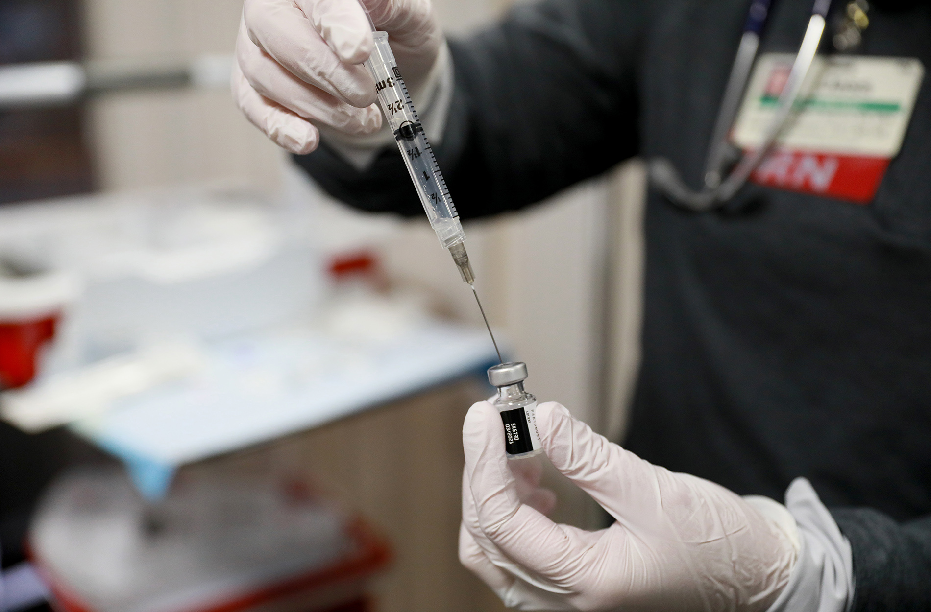 Nurse drawing COVID-19 vaccine from vial into syringe