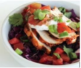 Burrito bowl of beans and peppers topped with chicken and a sprinkle of cilantro