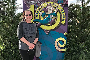 Carrie posing by Dopey Challenge statue