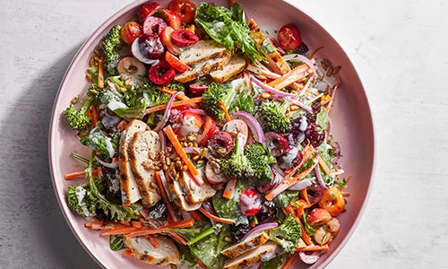 Chicken and cherry salad on pink plate