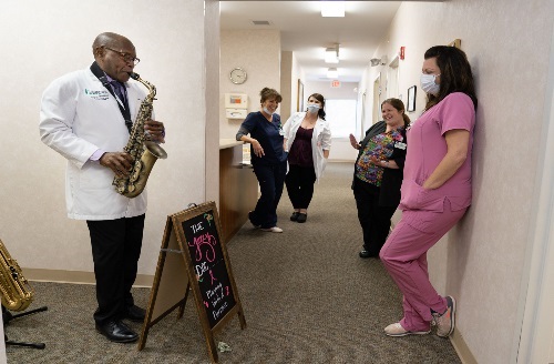 Dr. Marion playing saxophone in office