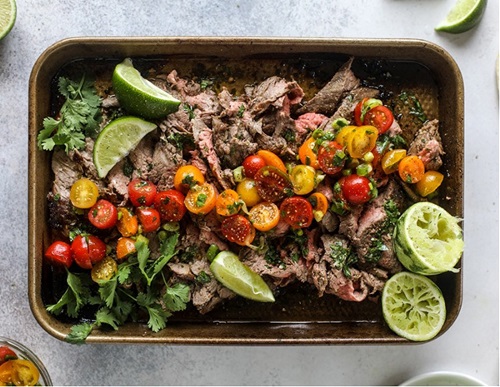 carved flank steak surrounded by vegetables