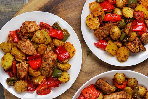 Roasted chick, potatoes and bell peppers in bowl