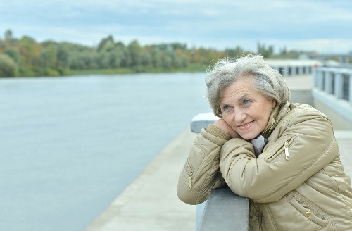 Older woman looking happily towards a lake