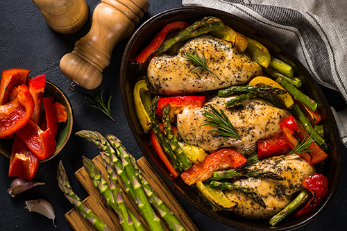 Baked chicken with asparagus succotash in skillet