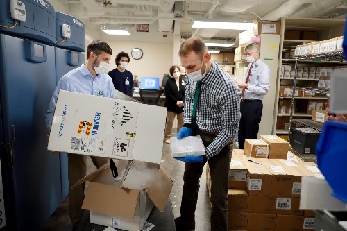 Pharmacist removing COVID vaccine from dry ice shipping box